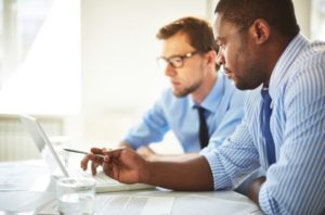 two-men-looking-at-laptop-one-pointing