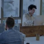 people-sitting-desks-computer-screens-knight-on-horse-holding-banner